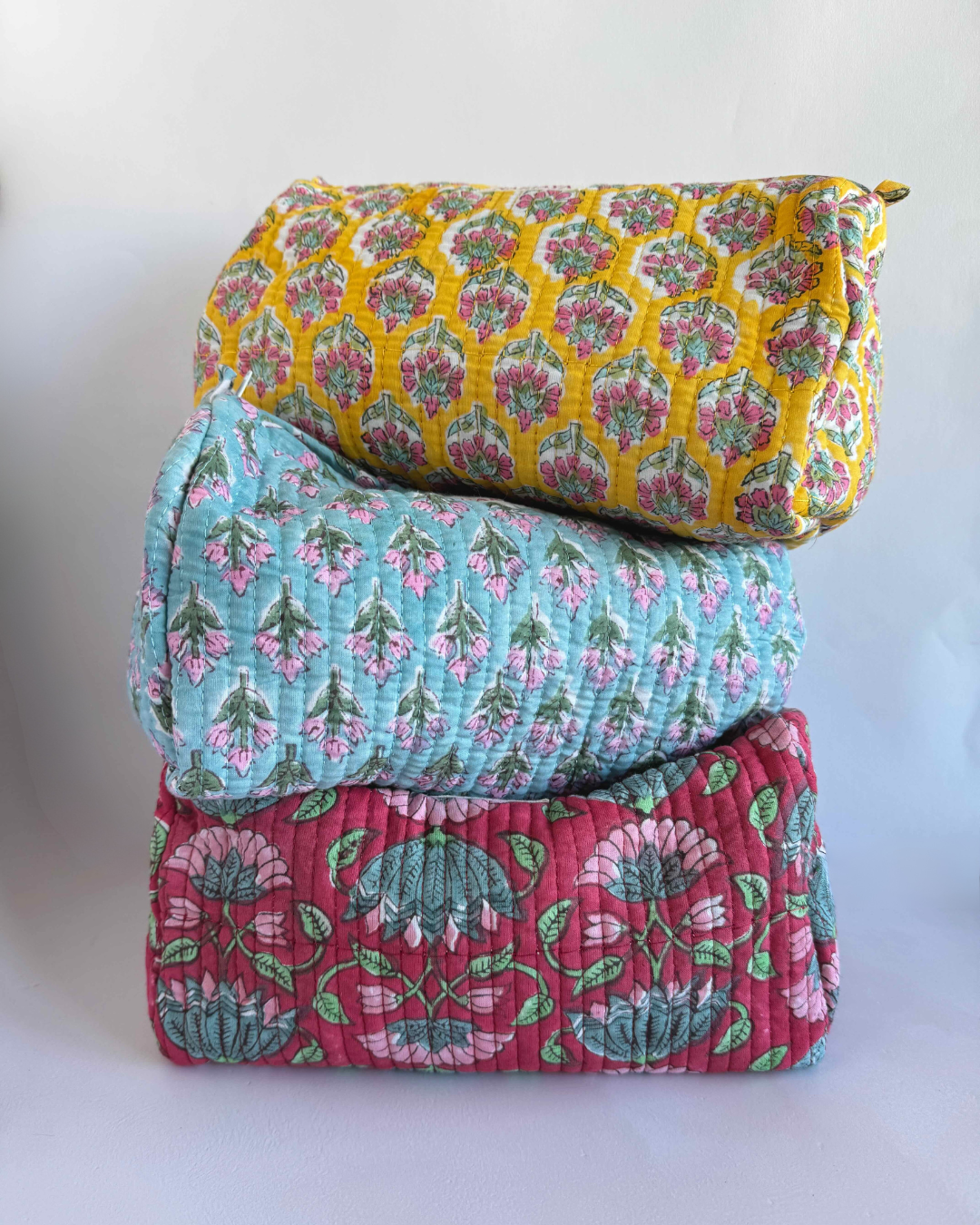 a pile of three round block printed pouches in front of a white background 