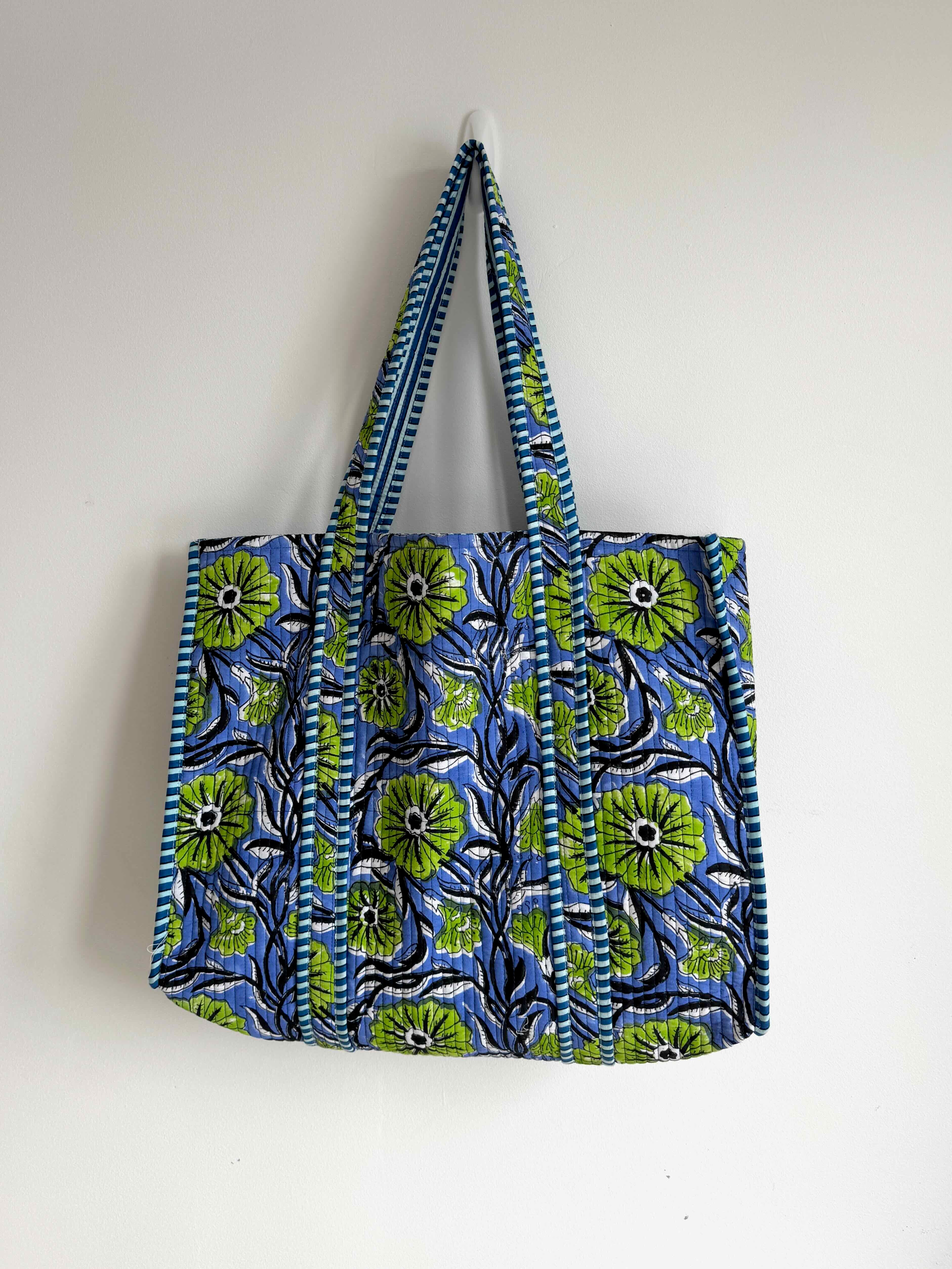 Tote bag with blue and green floral pattern on a white background