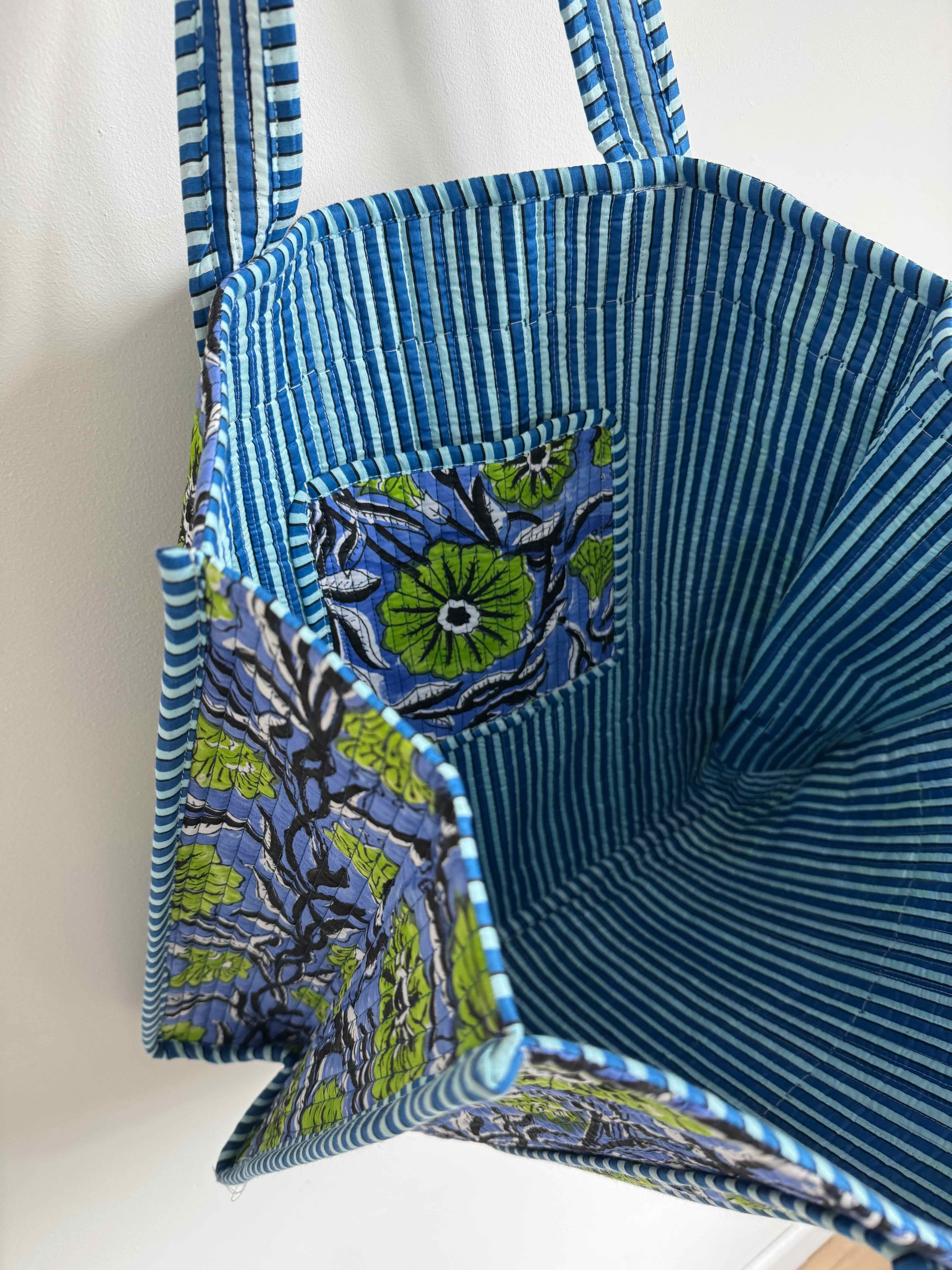 Blue striped bag with floral pocket on a white background